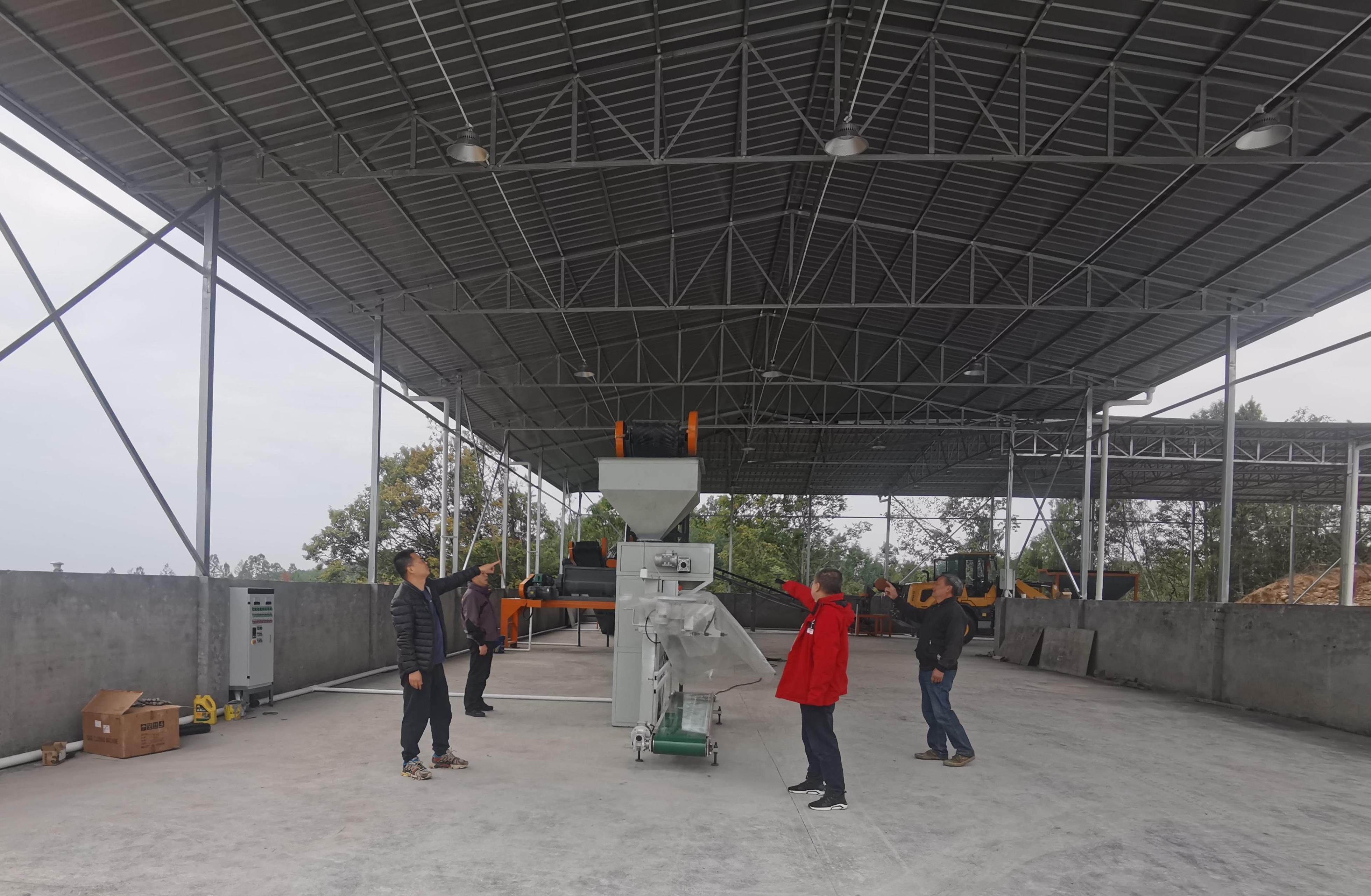 李杰超（左一）與村社干部、駐村隊員查看有機肥廠設(shè)備采購情況